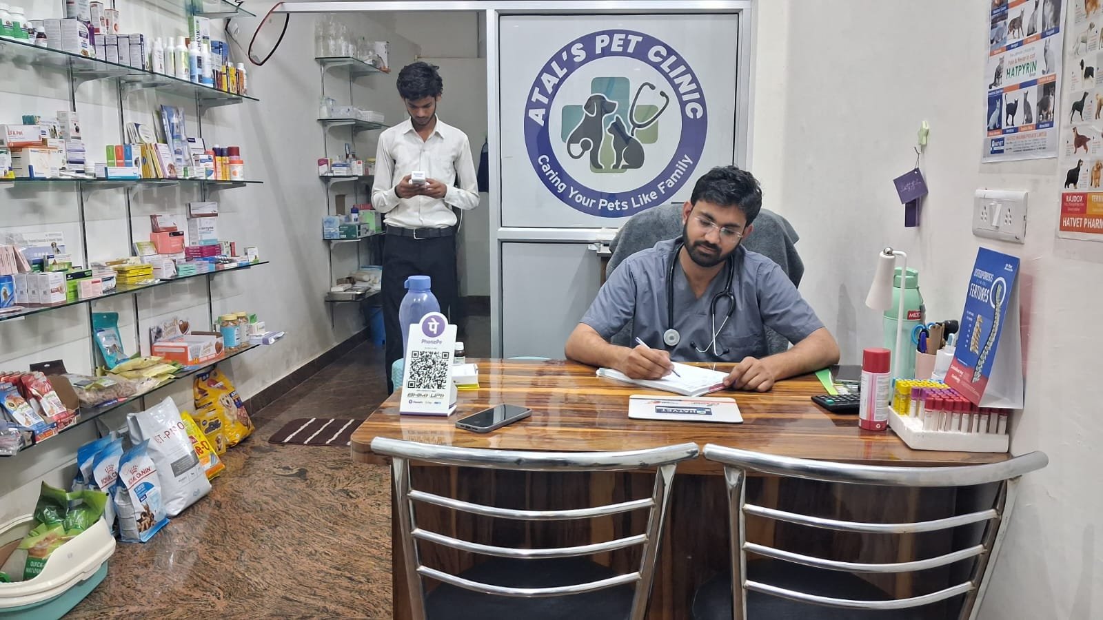 Dr. Avinash Atal at his desk at Atal's Pet Clinic Jaipur with clinic signboard visible